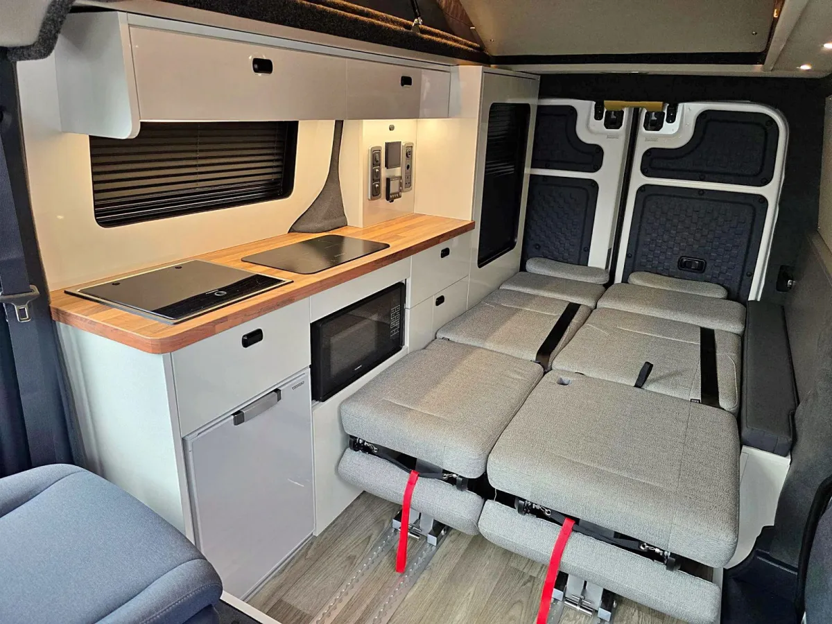 Hecha con una furgoneta Kia, esta camper tiene, en solo 4,69 m, dos asientos y dos camas dobles que cambian por completo las vacaciones